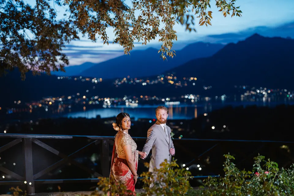 Sara and Leo on a terrace above the lake at night.